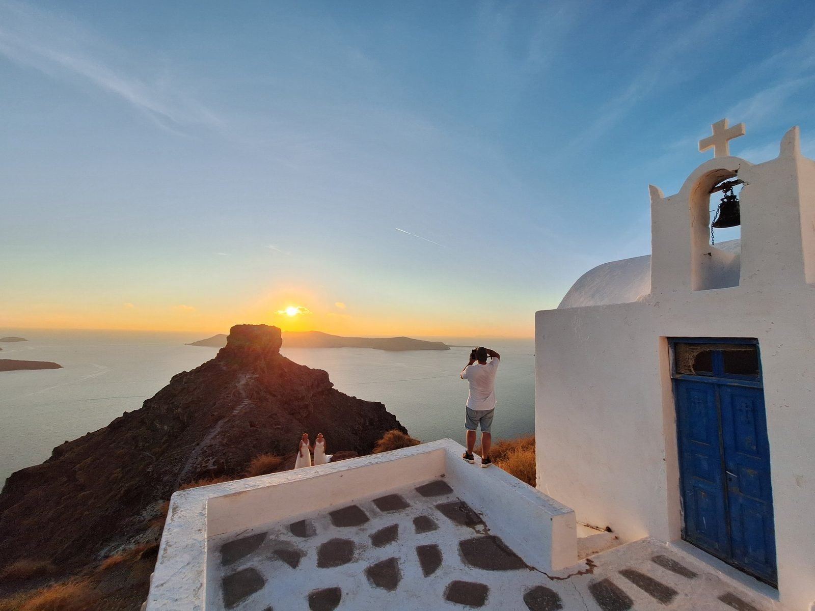 Scouting a wedding shoot with a photographer at a chapel above Skaros Rock, Imerovigli, at sunset